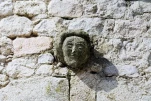 Tête en pierre sculptée, remploi dans un mur de maison (MONTPEZAT)